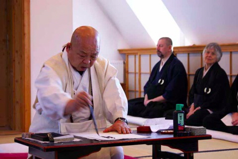 Hier siehst du den Zen-Meister Hozumi Roshi, wie er eine Kalligrafie erstellt.
